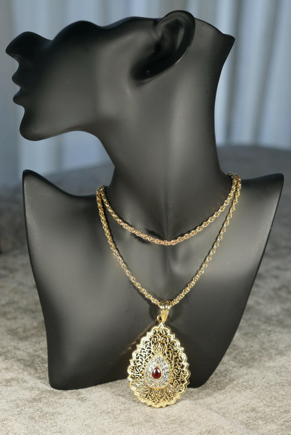 gold coloured necklace pendant twisted