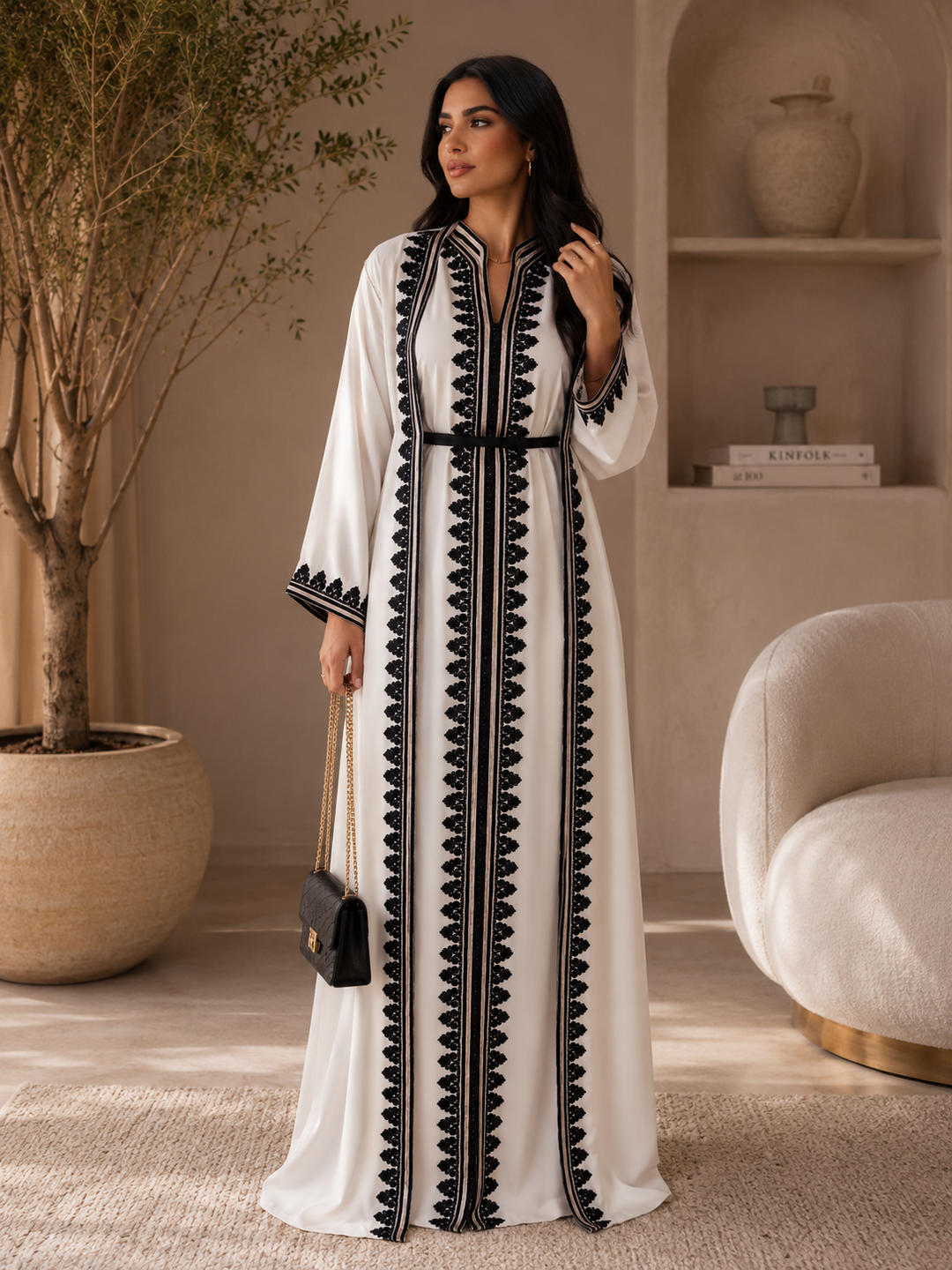 Elegant ivory Moroccan caftan with intricate black embroidery and flowing full-length silhouette.