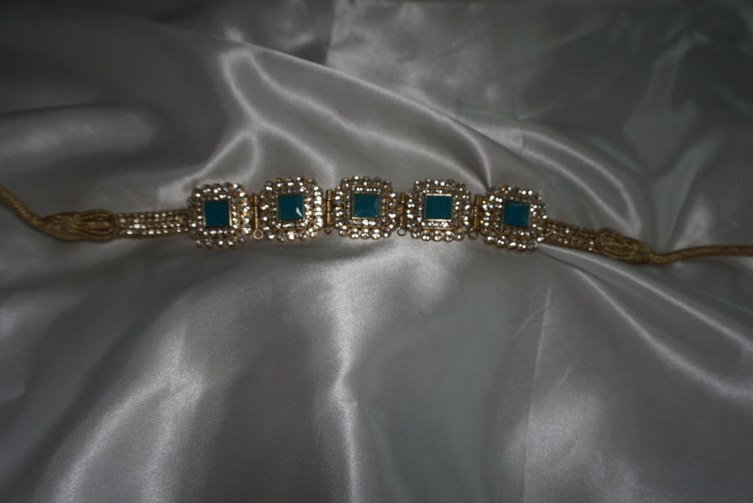 Gold Moroccan waist belt with emerald green gem details on satin background – traditional statement belt for kaftans or special occasions