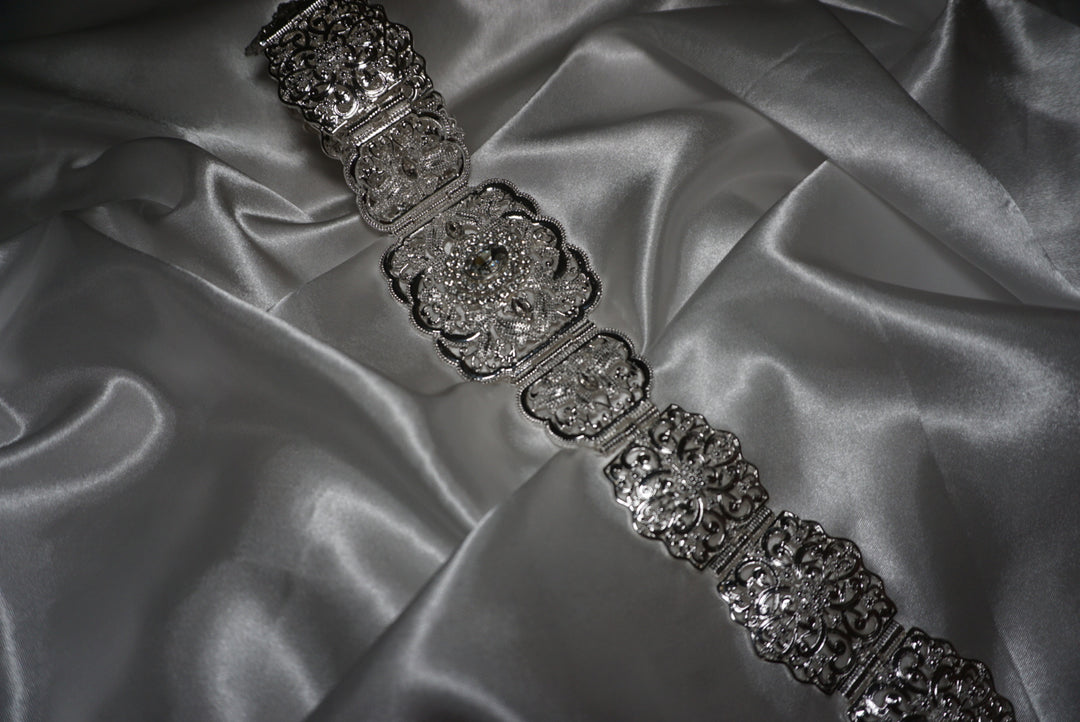 Silver Moroccan waist belt with intricate filigree design and crystal detailing – bridal and occasion belt for kaftans and abayas on satin background
