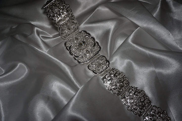 Silver Moroccan waist belt with intricate filigree design and crystal detailing – bridal and occasion belt for kaftans and abayas on satin background