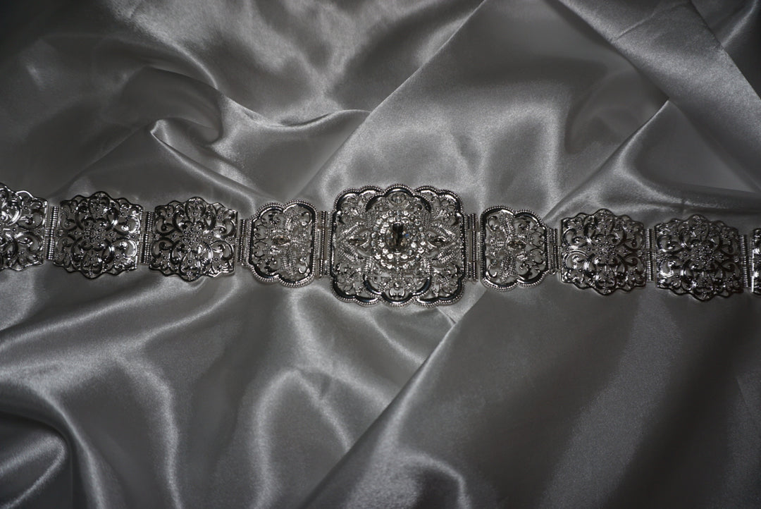 Silver Moroccan waist belt with intricate filigree design and crystal detailing – bridal and occasion belt for kaftans and abayas on satin background