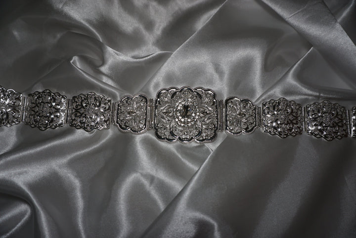 Silver Moroccan waist belt with intricate filigree design and crystal detailing – bridal and occasion belt for kaftans and abayas on satin background